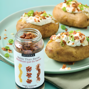 Open jar with one of the Top 10 Epicure products - Better Than Bacon Topper sitting beside a plate with 3 loaded Baked Potatoes.